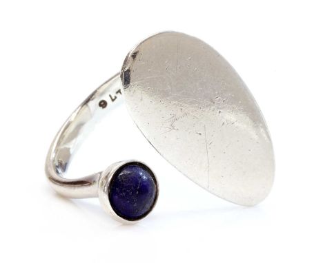 A sterling silver lapis lazuli ring, by Georg Jensen,no. 176, designed by Bent Gabrielsen. Of torque form, with a flat oval p