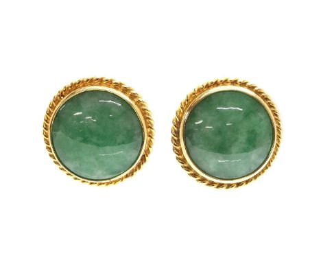 A pair of jade earrings,with a circular cabochon jade, rub set to a collet with a twisted wire border. Later omega and post f