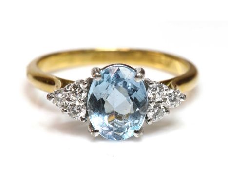 A gold aquamarine and diamond ring,with an oval mixed cut aquamarine, with a trefoil of brilliant cut diamonds at each side, 