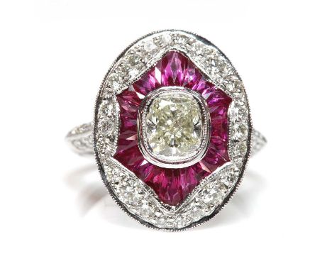 An Art Deco-style platinum diamond and ruby target cluster ring,with a cushion cut diamond, with a stated weight of 1.01ct, m