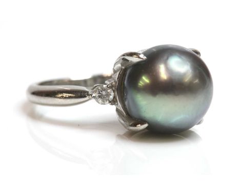 A cultured Tahitian pearl and diamond ring,with a 10.60mm cultured Tahitian pearl, peg and claw set to a plain collet. A bril