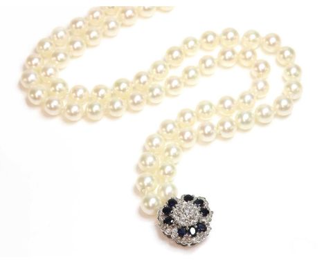 A two row uniform cultured pearl necklace, with a white gold diamond and sapphire cluster clasp, requires restringing. Two ro