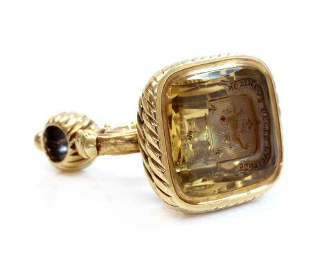 A gold mounted citrine seal, c.1820,with a cushion shaped faceted citrine, intaglio engraved with a coat of arms. Ribbon and 