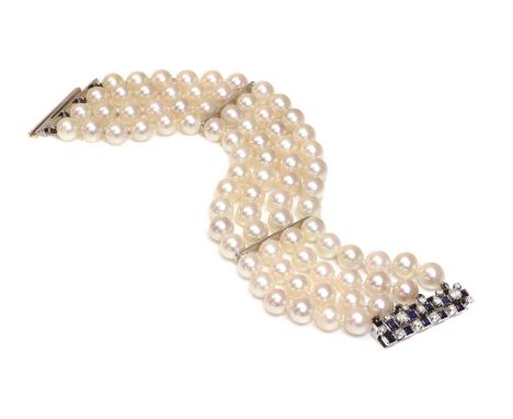 A four row cultured pearl bracelet,with a sapphire and diamond set clasp. Four rows of cultured pearls, 8 to 8.5mm in size, s