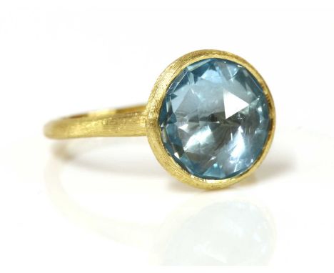 An 18ct gold single stone blue topaz 'Jaipur' ring, by Marco Bicego,with a circular Dutch rose cut blue topaz, rub set to a s