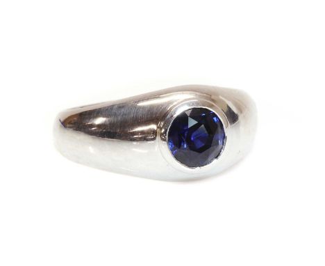 A white gold single stone sapphire ring,with a round mixed cut sapphire, rub set, to a domed tapered head, and 'D' section sh