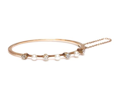 A former Austro-Hungarian pearl and diamond hinged bangle, c.1890,with three peg set pearls, between four cushion cut and cus