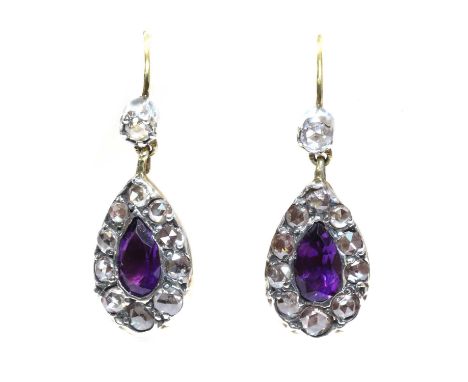 A pair of amethyst and diamond drop earrings,with a pear cut amethyst, surrounded by a row of graduated rose cut diamonds. Al