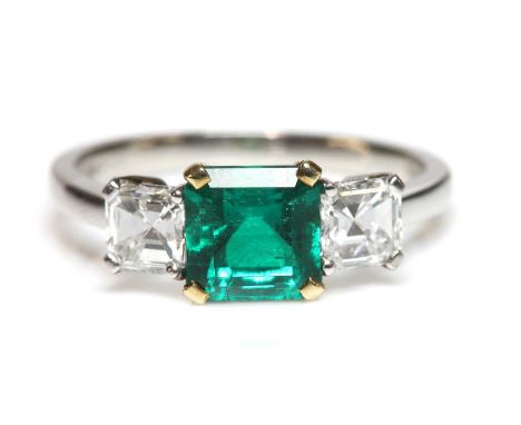 A platinum and gold three stone emerald and diamond ring, by Pravins, c.2002,with an emerald cut emerald, with a stated weigh