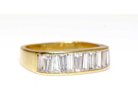 A Continental diamond set half eternity ring,of flat section, cushion shaped form, with a row of tapered baguette cut diamond