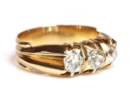 An Edwardian rose gold three stone diamond ring, c.1905,with three graduated old European cut diamonds, claw set in deeply sc