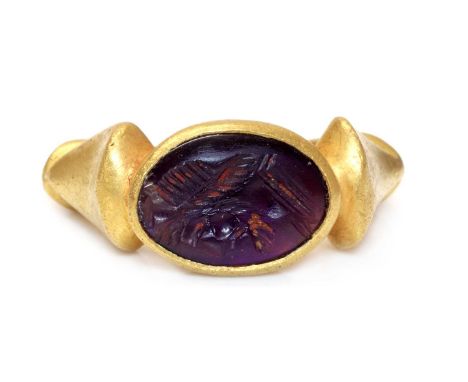 A Roman amethyst intaglio ring,with an oval cabochon amethyst, intaglio engraved with a warrior's head, rub set to a landscap