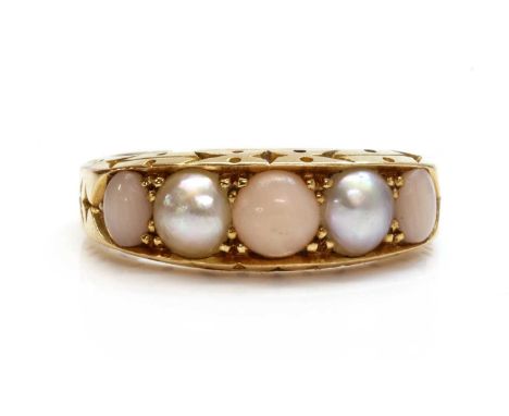 A late Victorian five stone coral and split pearl boat shaped ring,with three graduated angel skin coral cabochons, between t