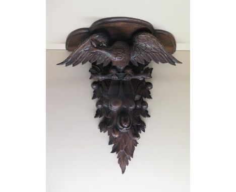 A carved wood Eagle fruit and berry clock bracket, 61cm tall x 56cm x 23cm deep, in generally good condition, fixing holes to