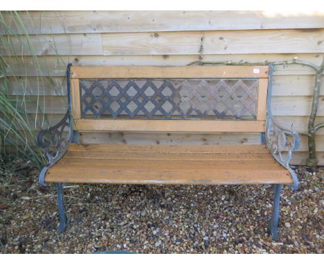 A cast iron wooden slatted garden bench, 127cm wide, in weathered condition 