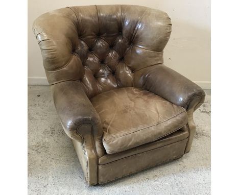 A Ralph Lauren aged brown leather button back winged scroll arm chair on turned front legs, 95 cm wide