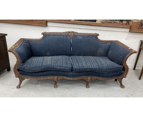 A circa 1900 French carved walnut framed sofa in the Louis XV taste, the foliate and floral decorated back over swept arms an
