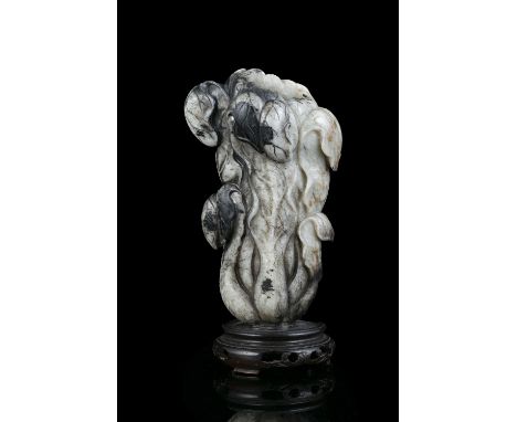 A MOTTLED JADE CARVING OF A CHINESE CABBAGE China, Likely Ming Dynasty Naturalistically carved in a mottled stone with dark i