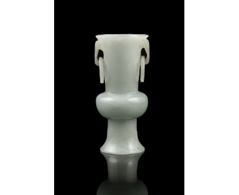 A SMALL JADEITE JADE BEAKER VASE WITH LOOSE RINGS HANDLES China, Qing Dynasty, Circa 1900 Carved out of a milky stone with ap