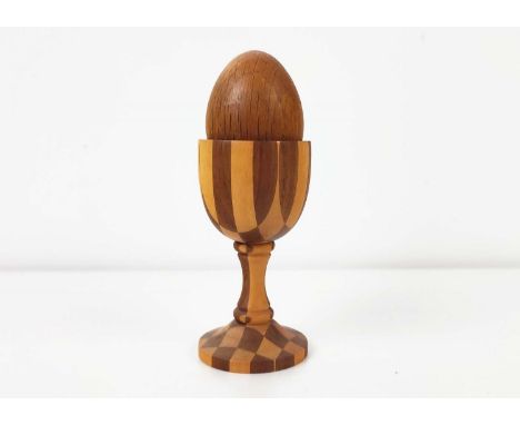 A LINLEY PARQUETRY TURNED EGG CUP, pedestal base, complete with oak egg, 10cm high, stamped to underside (2)