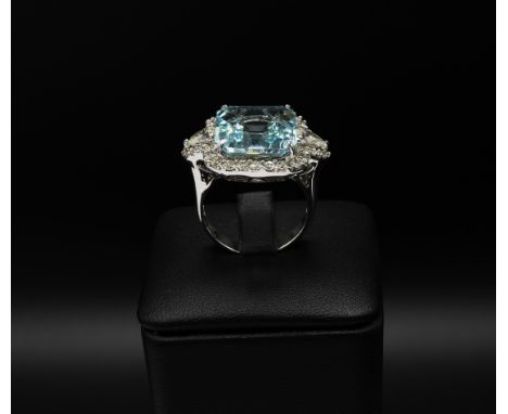 AN 18CT WHITE GOLD AQUAMARINE AND DIAMOND DRESS RING, set with a large octagonal aquamarine, surrounded by round brilliant cu