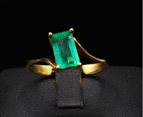AN 18CT YELLOW GOLD EMERALD DRESS RING, the emerald cut natural emerald claw set, ring size O, complete with box