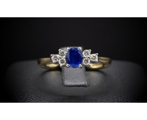 AN 18CT YELLOW GOLD SAPPHIRE AND DIAMOND DRESS RING, the central oval mixed cut sapphire flanked by six round brilliant cut d