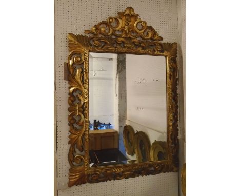 FLORENTINE WALL MIRROR, 19th century carved pierced giltwood with bevelled plate, cushion frame and scroll crest, 135cm H x 9