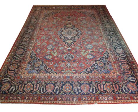 FINE ANTIQUE PERSIAN KASHAN CARPET, 435cm x 325cm, midnight blue pole medallion on a terracotta field of scrolling vines and 