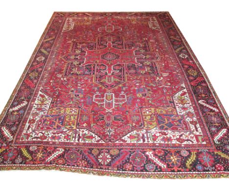 FINE PERSIAN HERIZ CARPET, 427cm x 310cm, geometric medallion on a terracotta field of stylised palmettes and vines within  c