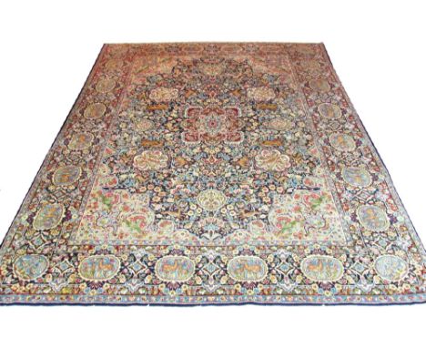 KERMAN CARPET, 387cm x 310cm, South Persia, the dark indigo field of profuse foliage and animals around a large pendant medal