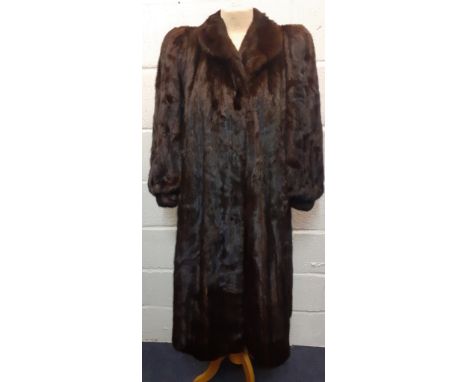 A 1980's dark brown mink coat (almost black to the eye) having a shawl collar, raised and padded shoulders with bellow sleeve