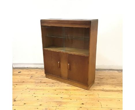 A 1930's oak display cabinet by Robert John Anderson of Edinburgh, the rectangular top above a pair of glass doors enclosing 