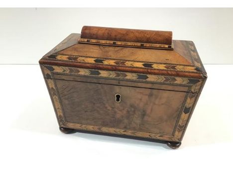 An early Victorian walnut tea caddy with Tunbridgeware banding, of sarcophagus form, raised on flattened bun feet. 15cm  by 2