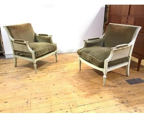 A pair of French painted bergere armchairs, c. 1900, each with fluted roller top rail and downswept arms with scroll terminal