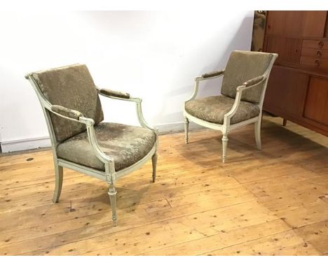 A pair of French painted fauteuils, c. 1900, each with fluted roller top rail and downswept open arms with scroll terminals, 