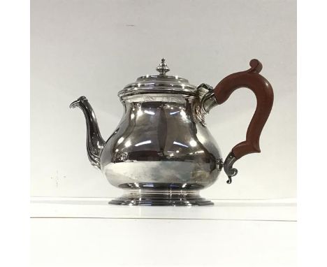 A silver teapot, C.J. Vander Ltd, London 1964, of squat baluster form, the stepped domed cover with urn finial, wooden handle