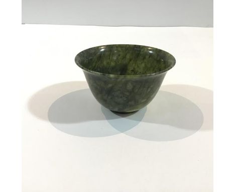 A Chinese spinach-green jade bowl, the plain body with gently flaring rim, on a ring foot, the translucent stone dark green w