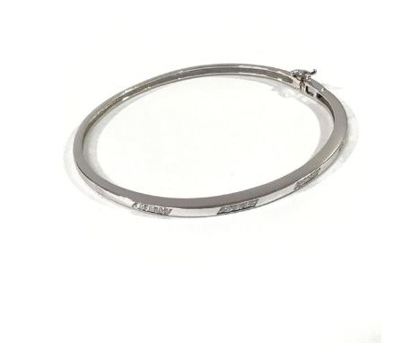 A diamond-set 18ct white gold bangle, the hinged tapering band set to one half with five lines each of four diamond points. I