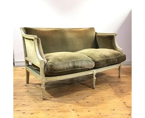 A French painted two seater canape sofa, c. 1900, with fluted roller top rail, downswept arms with scroll terminals enclosing