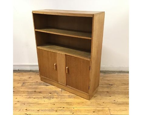 A 1930's oak bookcase cabinet by Robert John Anderson of Edinburgh, the rectangular top over two open shelves and a pair of c