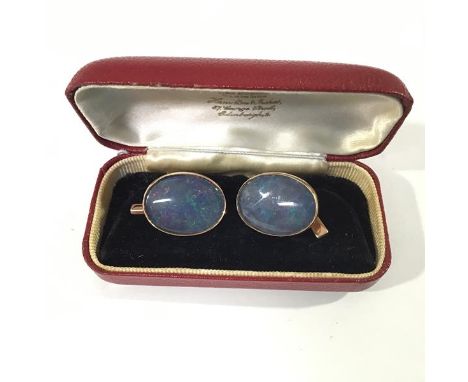 A pair of opal cufflinks, mounted in 9ct gold, each oval stone collet set on a chain and bar link, cased. Each opal 20mm by 1