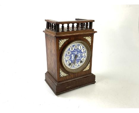 A 19th century oak cased Aesthetic Movement French mantel clock with blue and white enamelled dial set with Arabic numerals, 