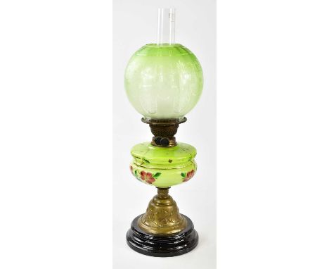 An early 20th century oil lamp, the globular green and clear frosted glass shade decorated with basket of flowers above the h