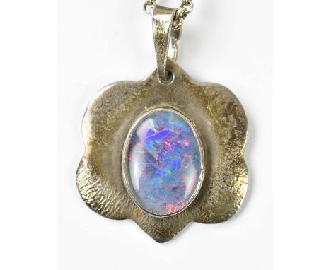 A white metal mounted doublet opal pendant suspended on a silver curb link chain.   Condition Report: Doublet opal measures a