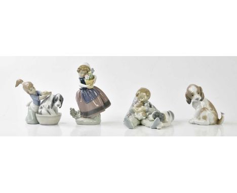 LLADRÓ; three figures and a model including a boy seated on a cushion beside a dog and three puppies, a girl holding a basket