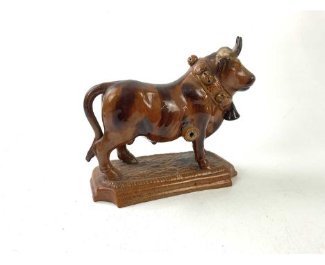 An unusual treacle glazed ceramic model of a bull, indistinctly stamped, length 24cm.