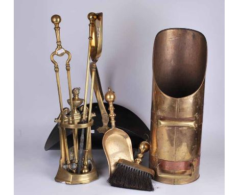 A set of Edwardian brass fireside companions in stand, together with dustpan and brush, toasting fork, log pan and coal chute