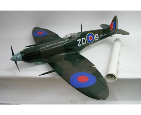 A large model remote control Spitfire with plans, approximately 40" long, a yellow and blue remote control model aircraft, a 