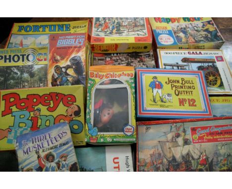 A box containing a collection of puzzles and  books including a first edition Biggles paperback  